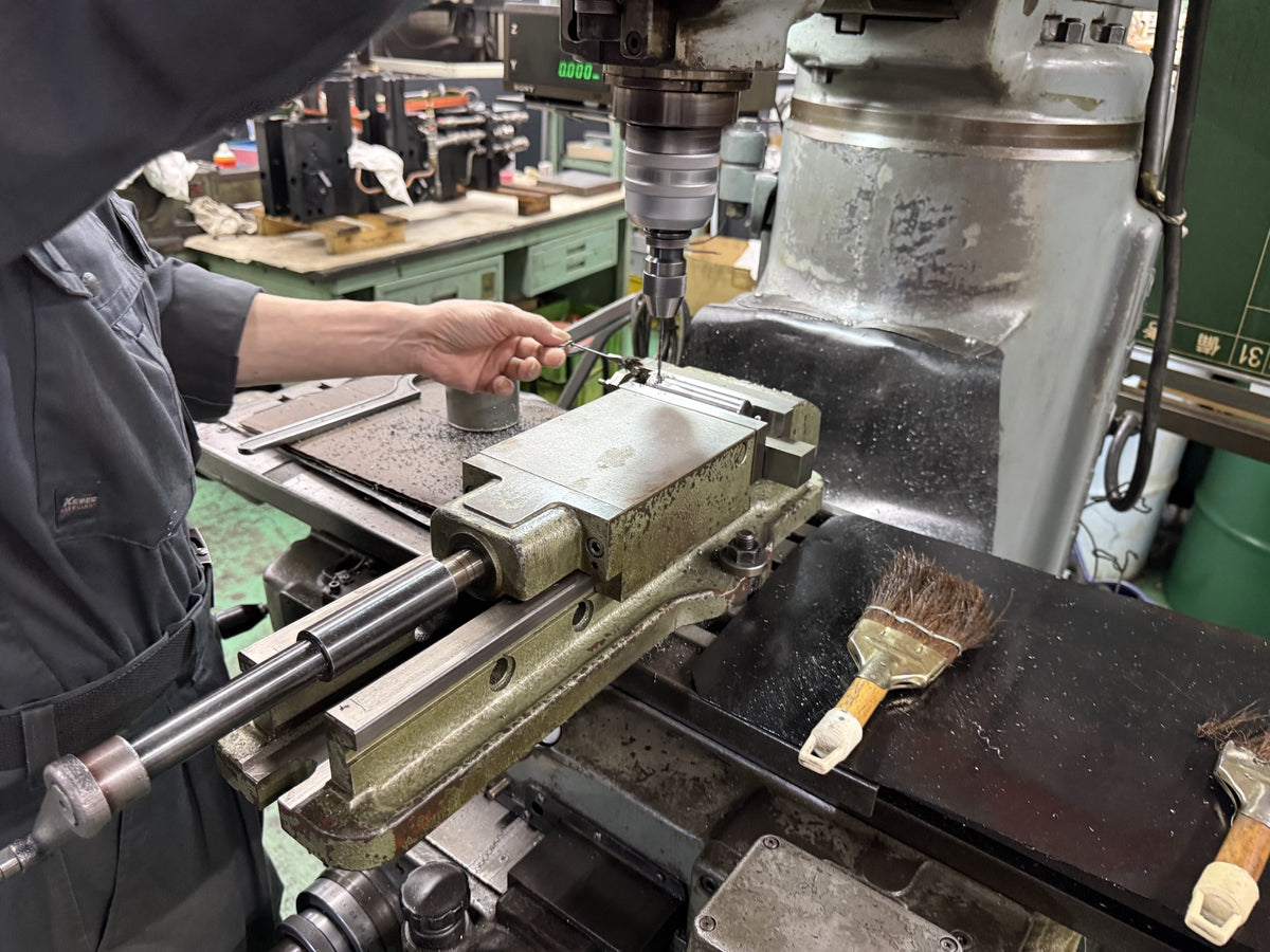 Tosho Seiko factory — drilling an aluminum block by hand